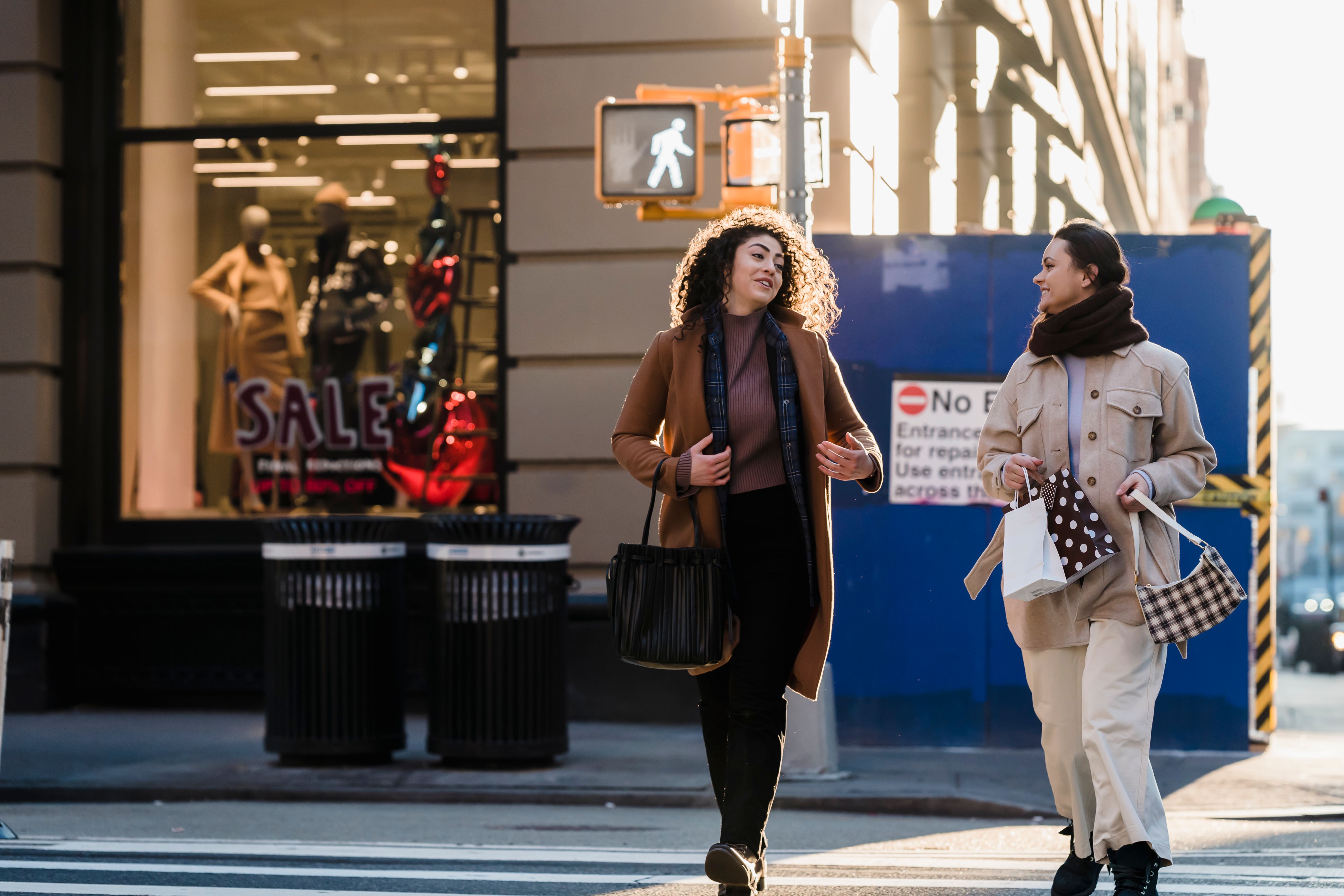 Two diverse friends talking as they walk through a city, showing how shared conversation can create intimacy.