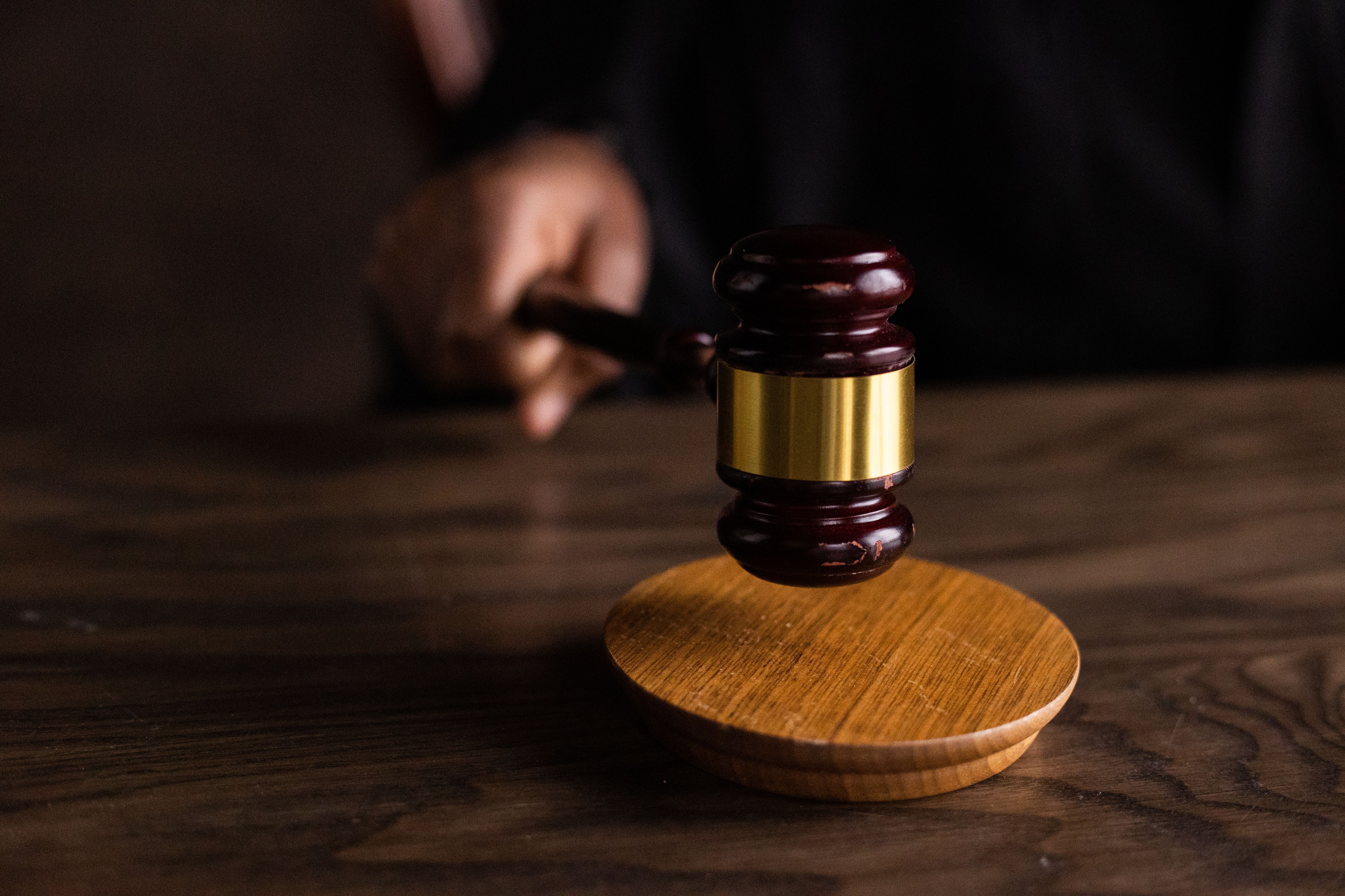 A gavel striking a sound block in a courtroom, symbolizing justice and legal authority in group claim proceedings
