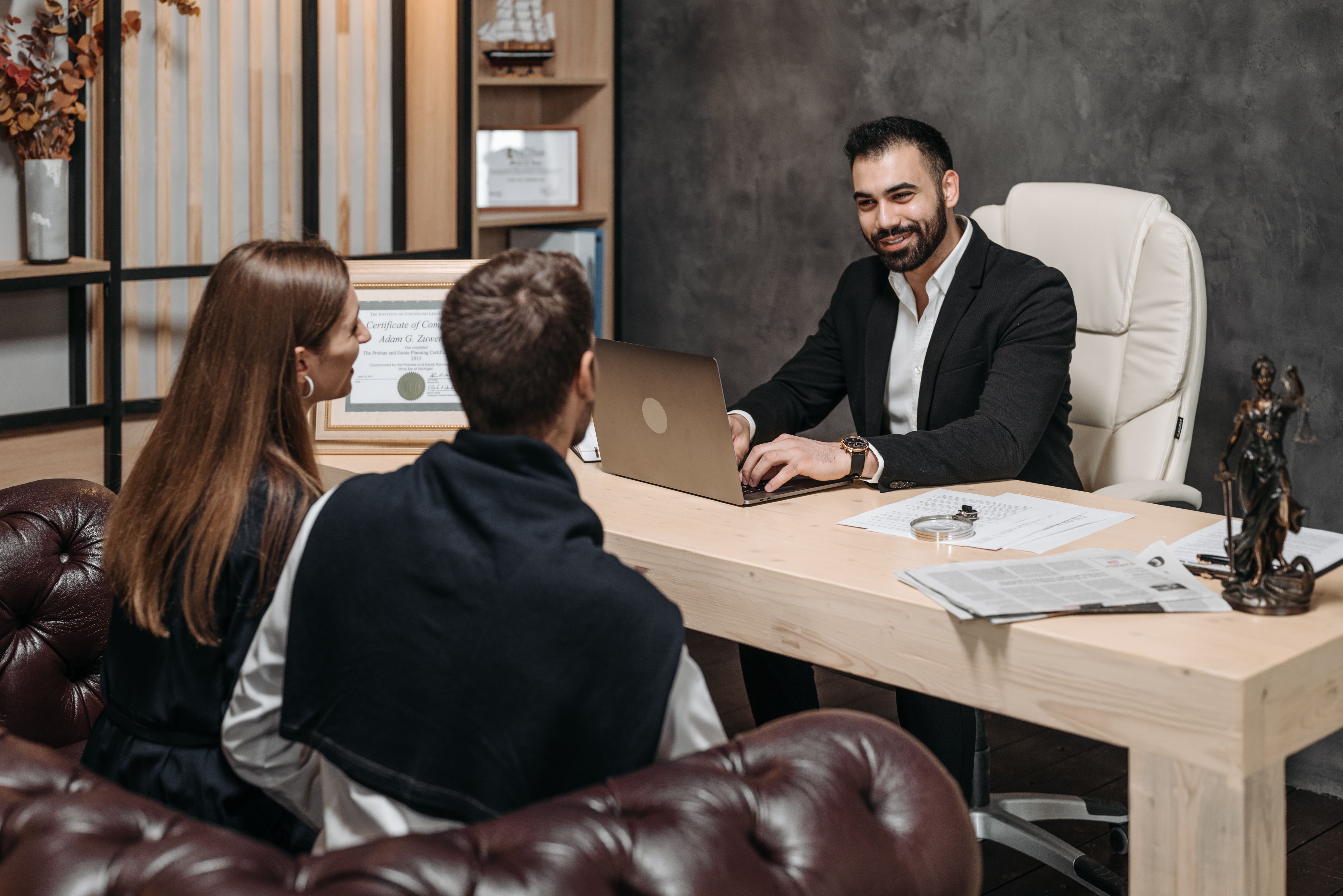 A lawyer consulting with clients in an upscale office, representing group claim legal advice and client representation
