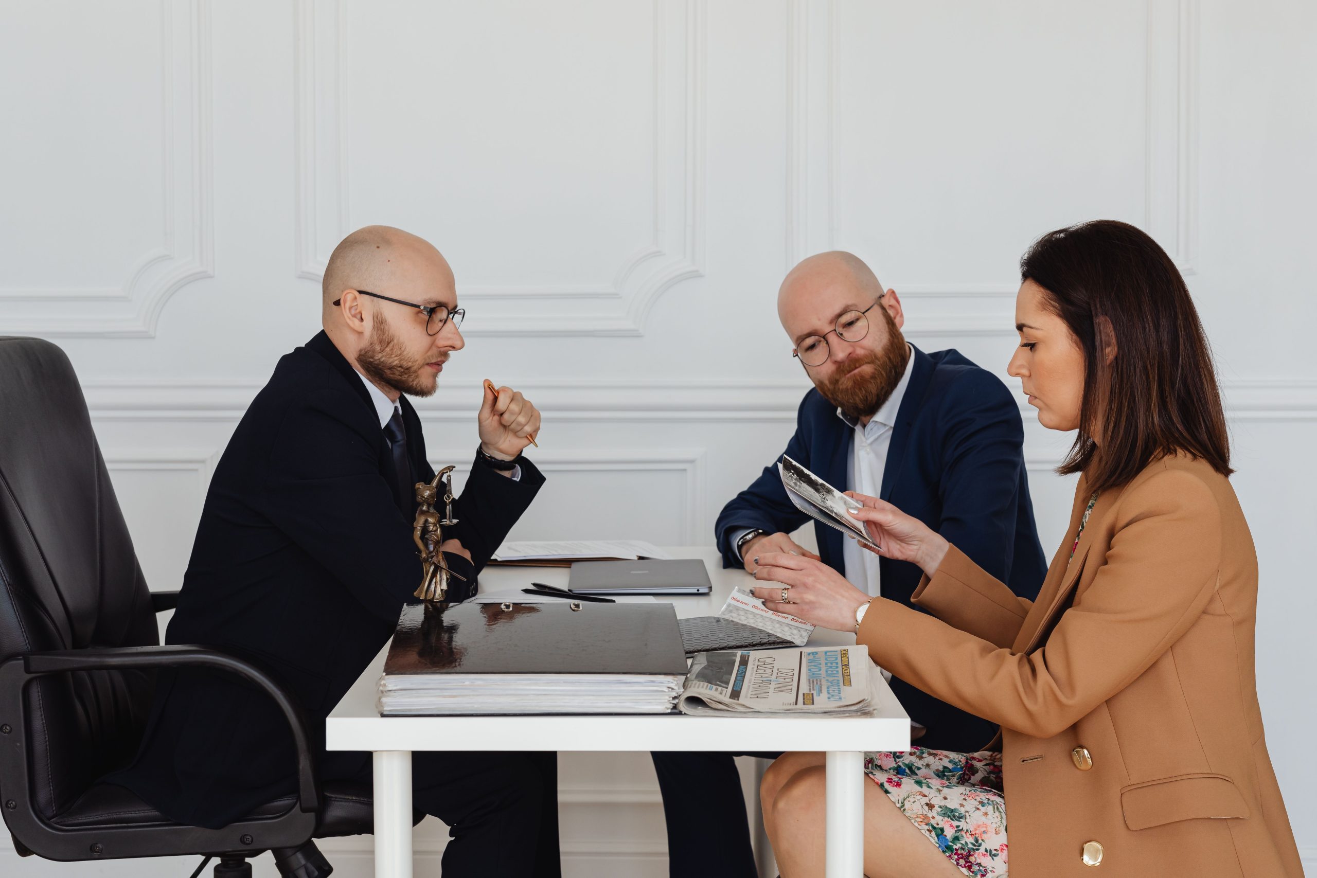 A group of legal professionals discussing and reviewing documents together in an office, illustrating how legal representation works in large group claims